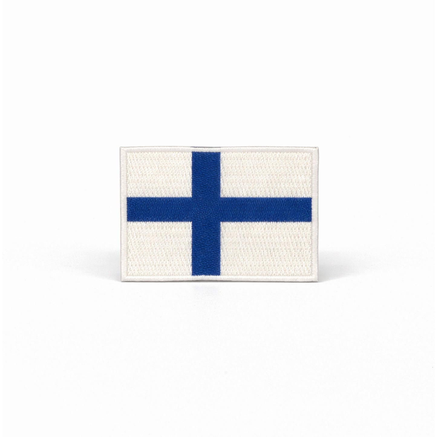 Broderat märke med Finlands flagga.