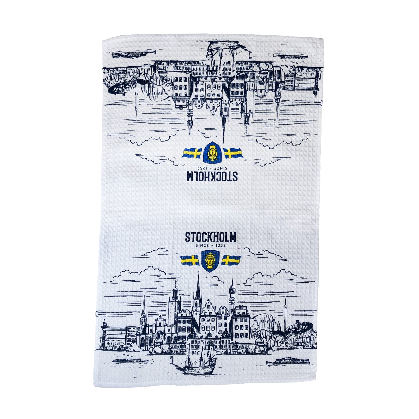 Vit kökshandduk med Stockholms stadsvy, texten Stockholm, Stockholms stadsvapen och två svenska flaggor.