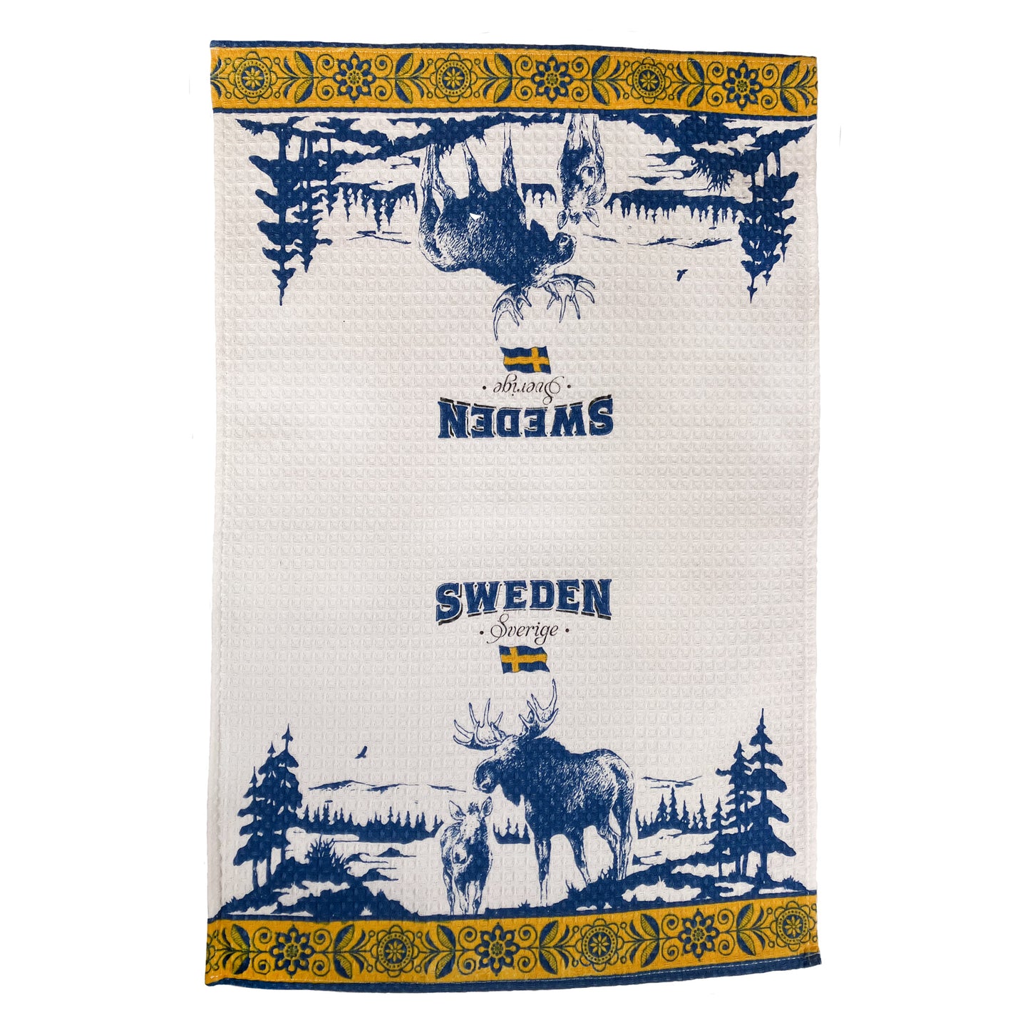 Vit kökshandduk med älgar, texten Sweden, svenska flaggan och en vacker skogsvy. Kökshandduken har också en gul kant med en blomstergirlang över och underkant.