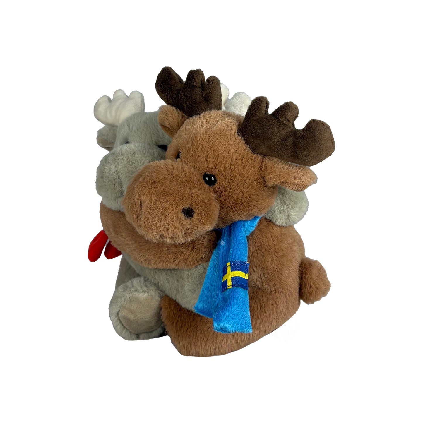 Två gosedjursälgar som kramas, en grå med iklädd en röd halsduk med svenska flaggan och en brun iklädd en blå halsduk med svenska flaggan. Fotograferade från sidan med brun älg närmast.
