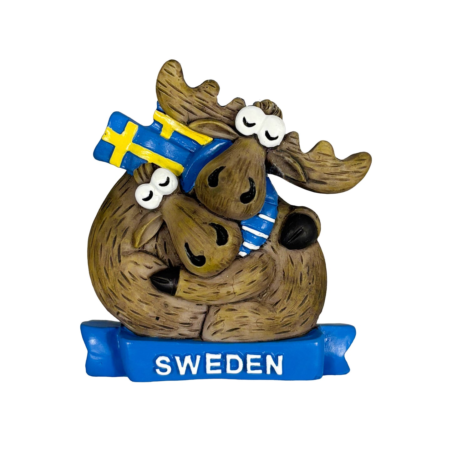 Magnet med två kramande älgar, en med halsduk med svenska flaggan. De sitter på en blå banderoll med texten Sweden. En kärleksfull souvenir med svensk känsla.