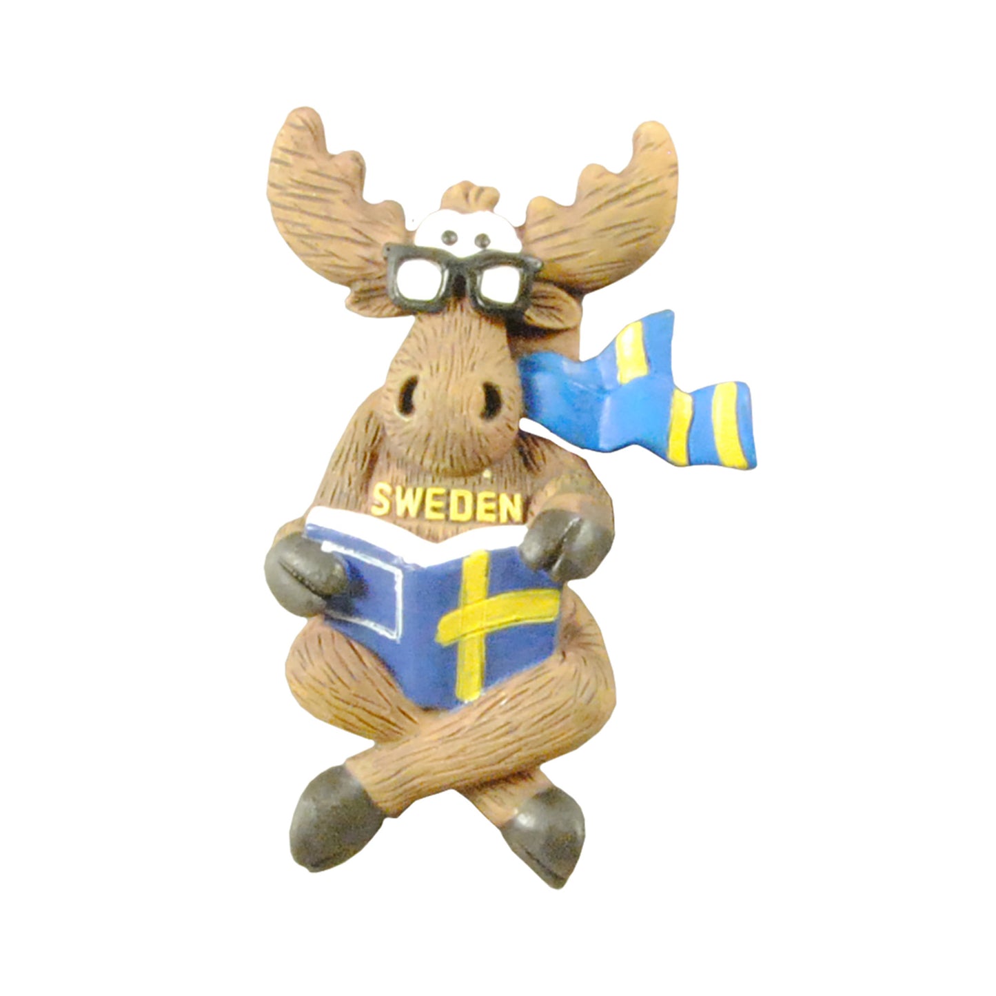 Magnet föreställande en älg med glasögon och halsduk i svenska färger, sittande med en bok med svenskt flaggomslag i knät. Texten "Sweden" finns på älgens bröst. En charmig och lekfull souvenir.