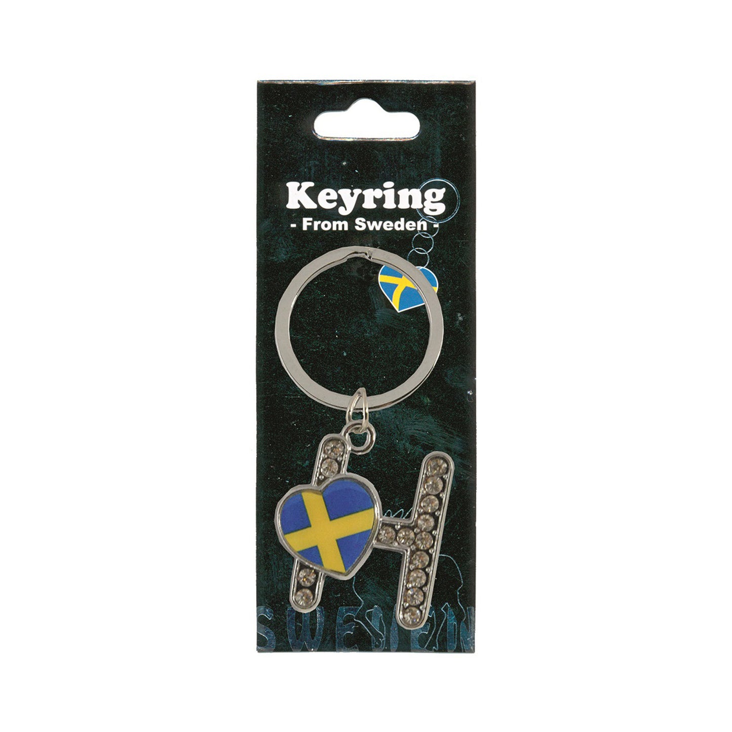 Metallnyckelring med bokstaven H. Bokstaven är dekorerad med glitterstenar. På bokstaven finns även ett hjärta med en svensk flagga. Visas här i sin förpackning. Svart förpackning med texten "Keyring från Sweden" i vitt.