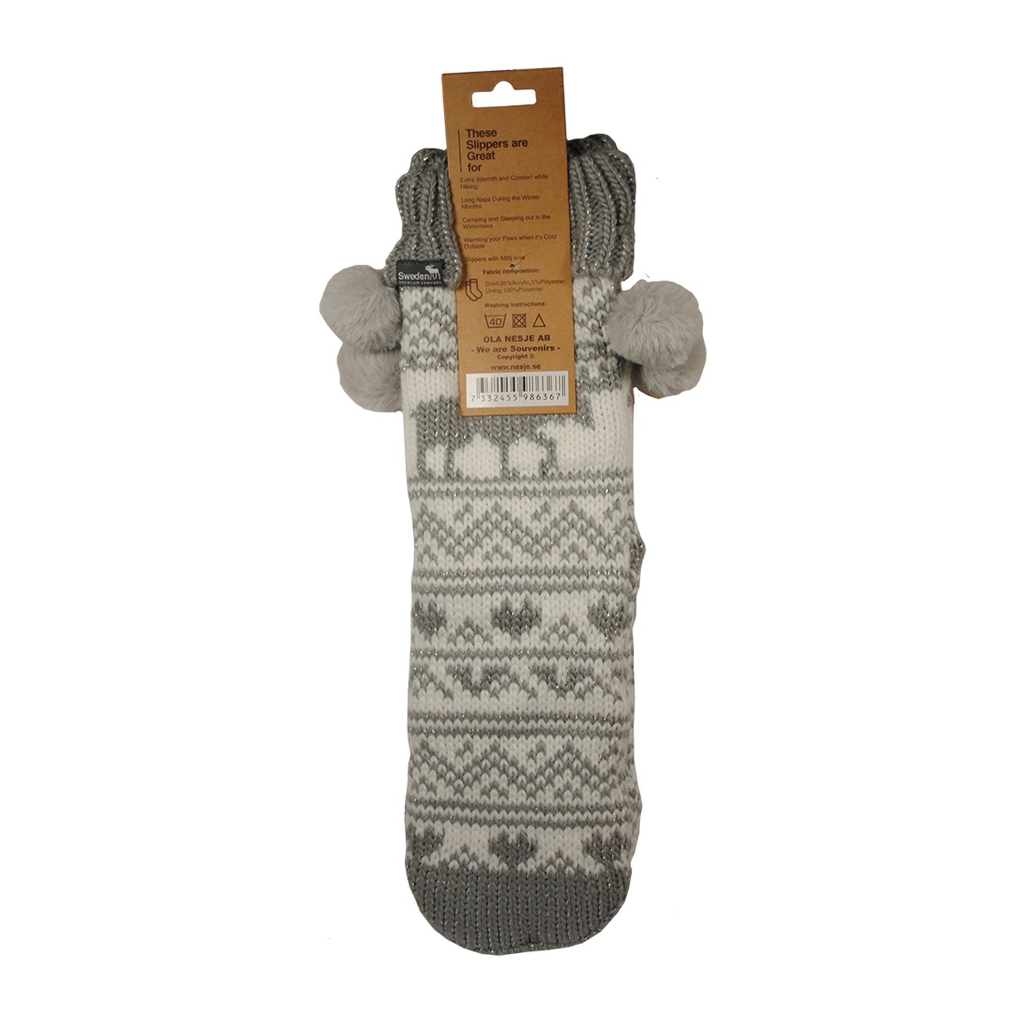 Baksida av vit och grå varmsocka med älgmönster och fyra pom poms, samt baksidan av hängetiketten med texten "These slippers are great for..." och tvättråd.