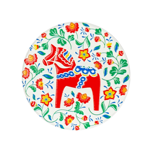 Rund magnet med röd dalahäst omgiven av blomster och gröna blad, en färgglad svensk souvenir.