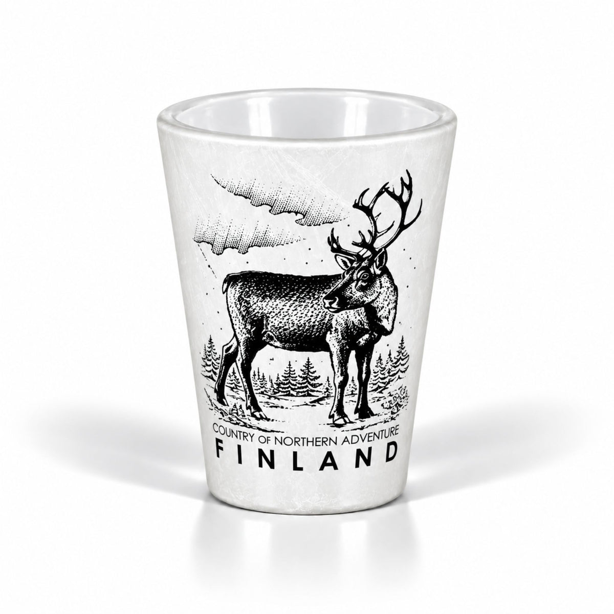 Vitt shotglas designat för att ge en isliknande yta, prytt med motiv av en ren och texten "Finland – Country of northern adventure".