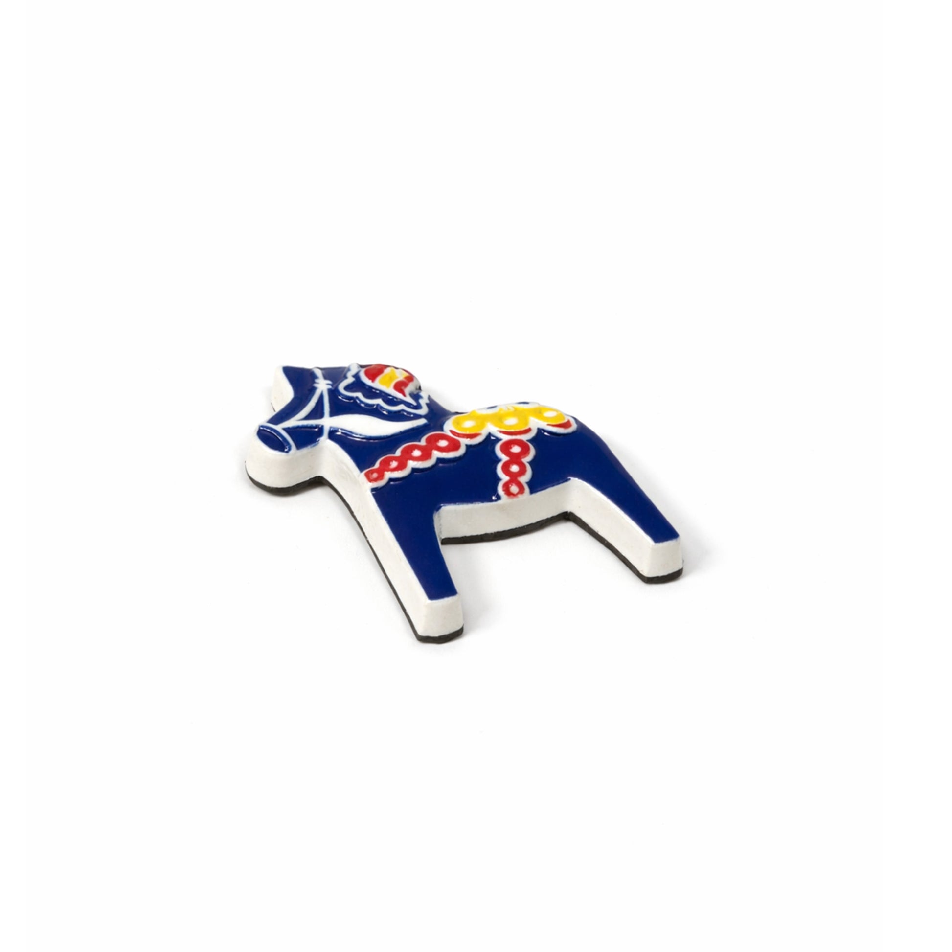 En blå liten charmig dalahästmagnet med röda, gula och vita detaljer. Visas här liggandes.