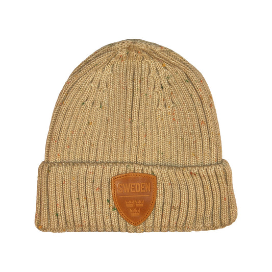 Beige stickad mössa med lädermärke prytt med motivet Tre Kronor och texten "Sweden". 