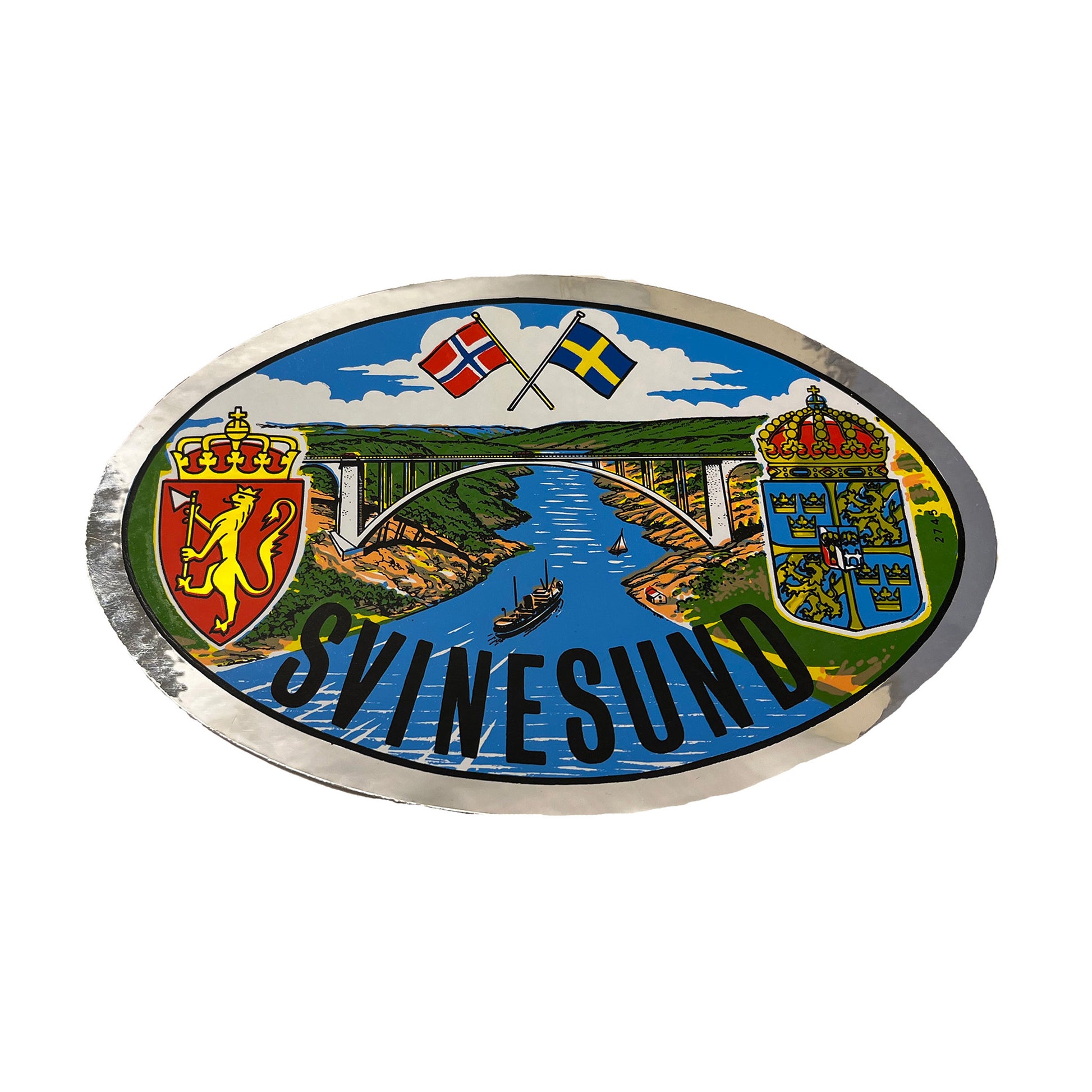 Oval bildekal 17 x 11 cm med motiv av Svinesundsbron och norska samt svenska flaggan.









