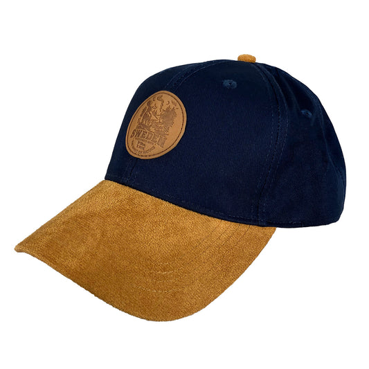 Blå keps med rund läderpatch och naturmotiv, brun skärm och justerbar passform – stilren keps med texten “SWEDEN wilderness with the Spirit of Nature”.