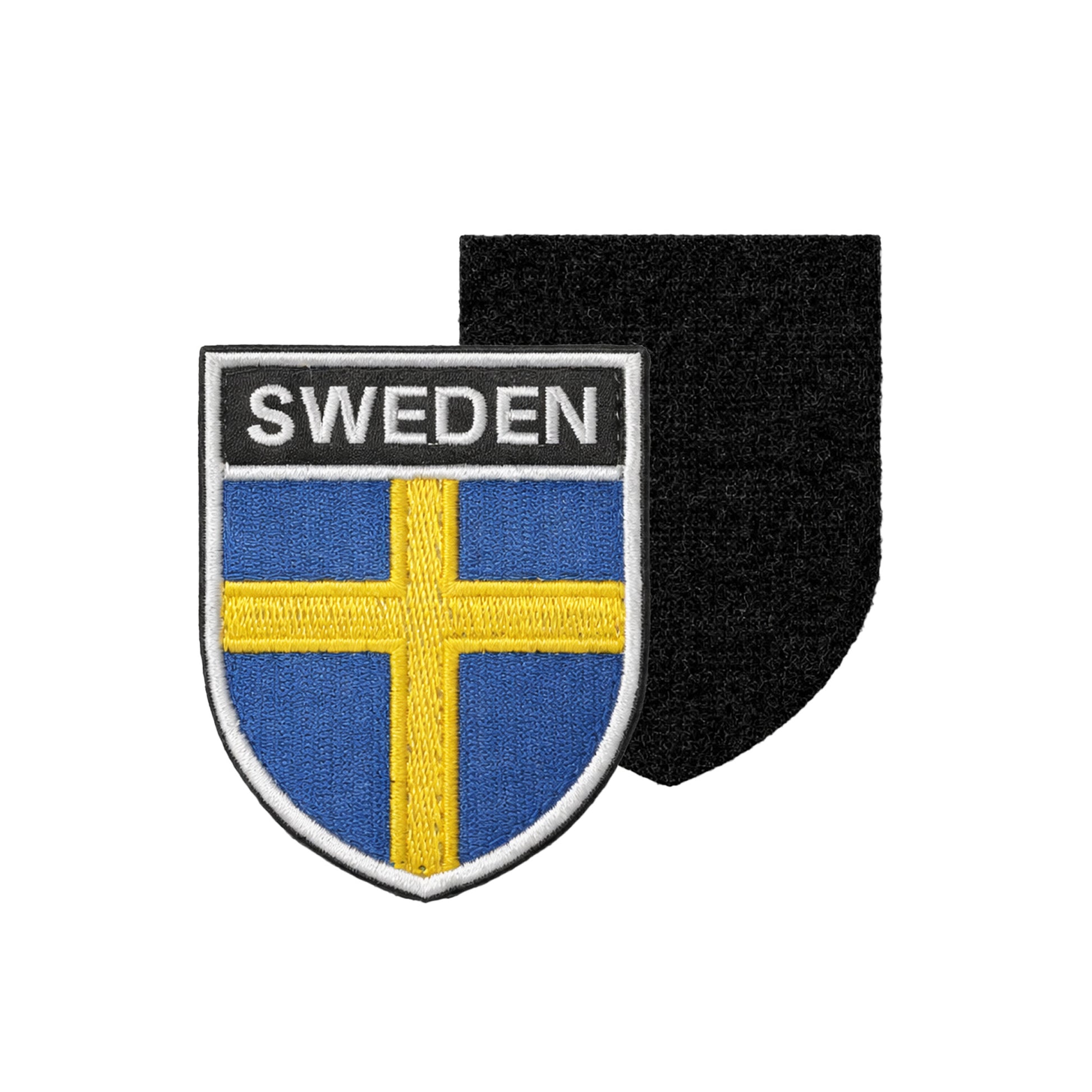 Broderat märke i sköldform med texten “SWEDEN” ovanför svenska flaggan, med svart kardborre baksida för enkel fastsättning. 