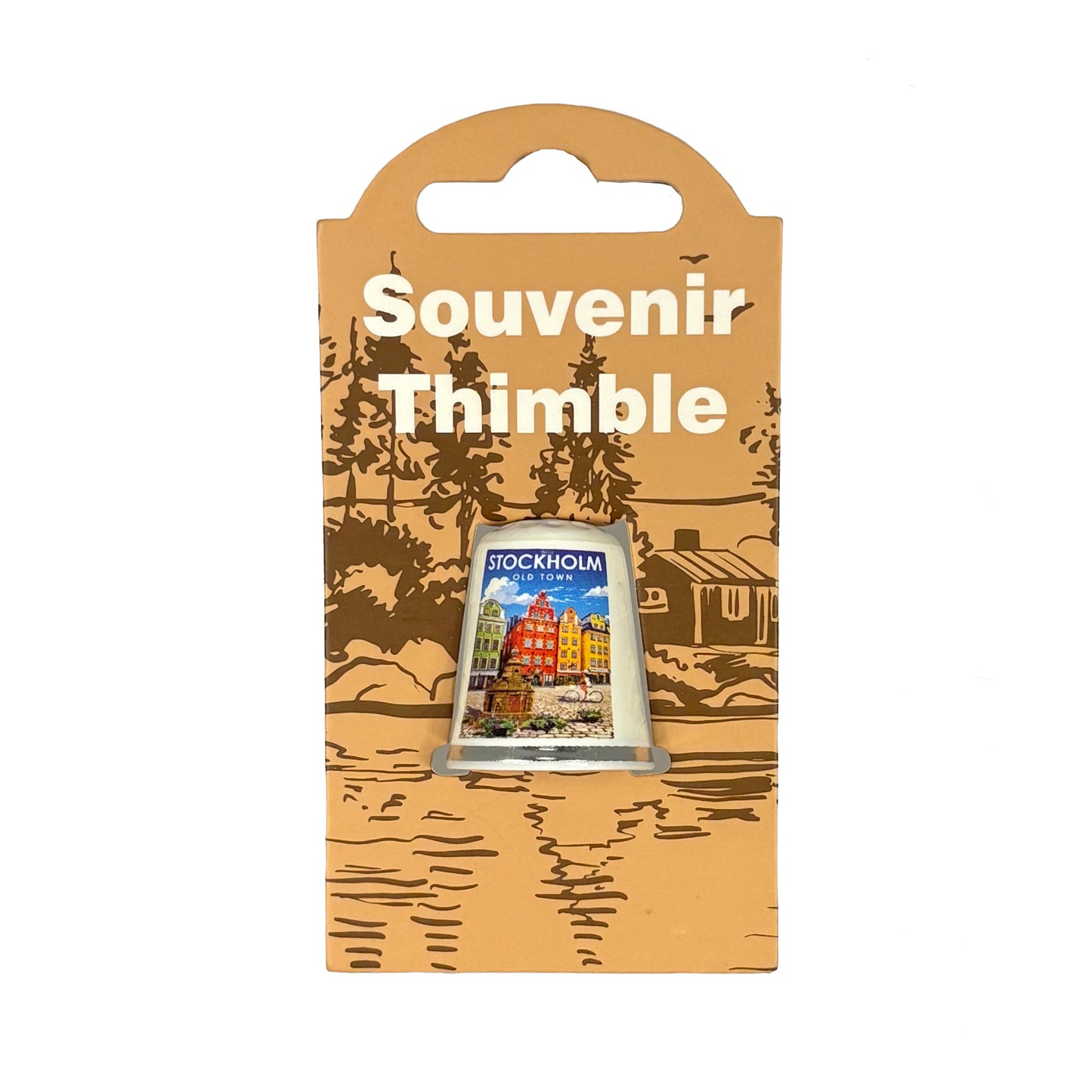 Fingerborg med motiv från Gamla Stan i Stockholm och texten "Stockholm Old Town". Perfekt som souvenir eller present. Visas här i sin förpackning = ljusbrun hängetikett med mörkbrunt skogsmotiv och texten "Souvenir Thimble" i vitt. 