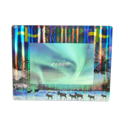 Fotoram i glas med texten "Northern Lights Sweden", norrskensmotiv och vildmarksscen.