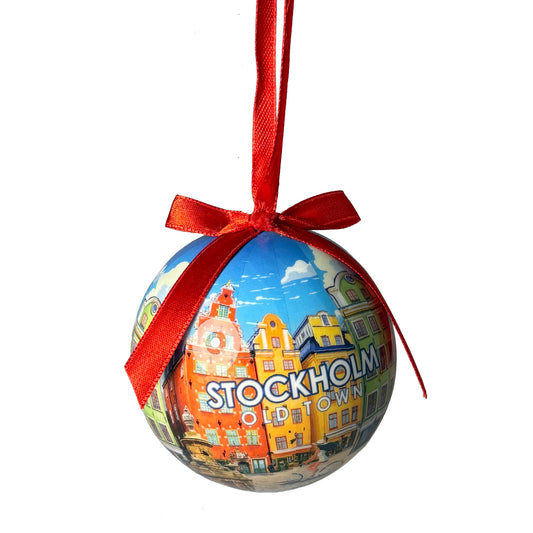 Julgranskula med motiv av Stortorget i Gamla stan, Stockholm. Kulan hängs upp med ett rött band.