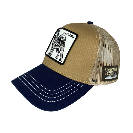 Ljusbrun och blå truckerkeps med ett märke framtill som visar en husky och texten Lapland. På sidan sitter ett mindre märke med texten “ARCTIC REGION OF EXTREMES”. Kepsen har nätdel bak och justerbar storlek.