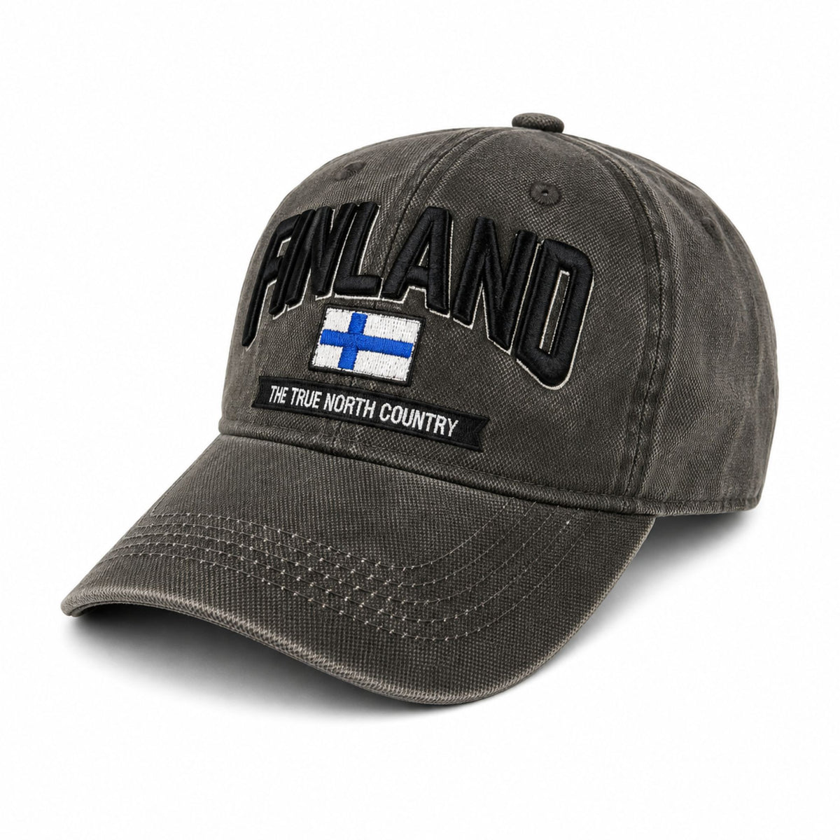 Grå vaxad keps sedd snett framifrån med broderad finsk flagga och texten Finland i 3D. Den vaxade ytan ger kepsen en distinkt look och känsla.
