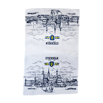 Vit kökshandduk med Stockholms stadsvy, texten Stockholm, Stockholms stadsvapen och två svenska flaggor.