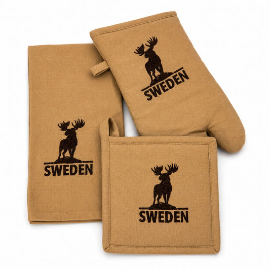 Beige set med grytlapp, grytvante, och köksandduk alla med älgmotiv och texten "Sweden".
