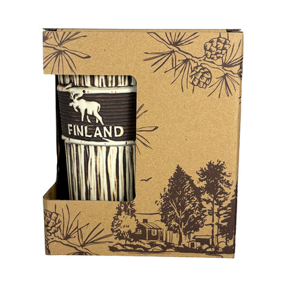 Lattemugg med träliknande yta, stiliserad älg och texten Finland, i brun pappförpackning med mörkt skogsmotiv – vy framifrån.