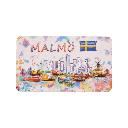 Färgglad souvenir­magnet med Malmös stadssiluett, svenska flaggan och texten "Malmö", med motiv som ser ut att vara målat i akvarell/vattenfärg.