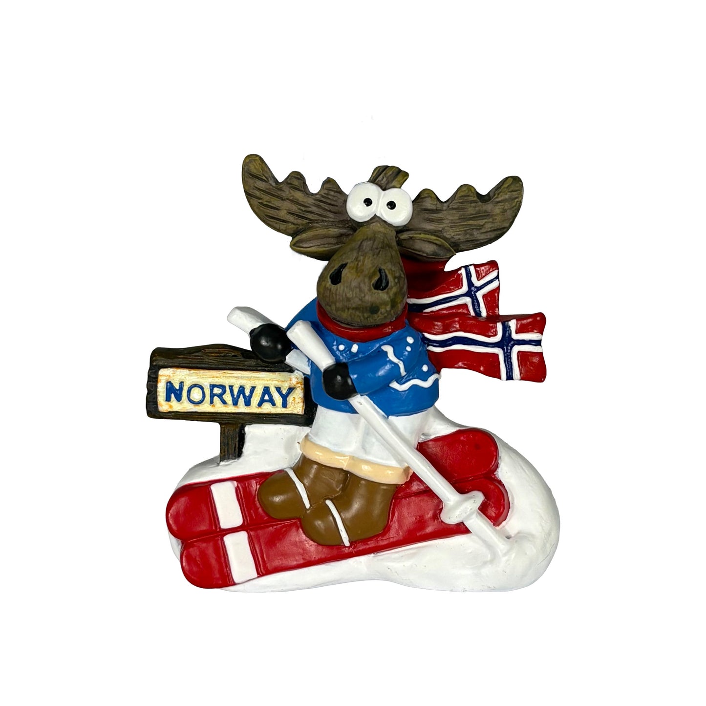 Magnet med skidåkande älg i blå tröja, röda skidor och halsduk med norska flaggan. En lekfull souvenir som fångar känslan av vinter och Norge.