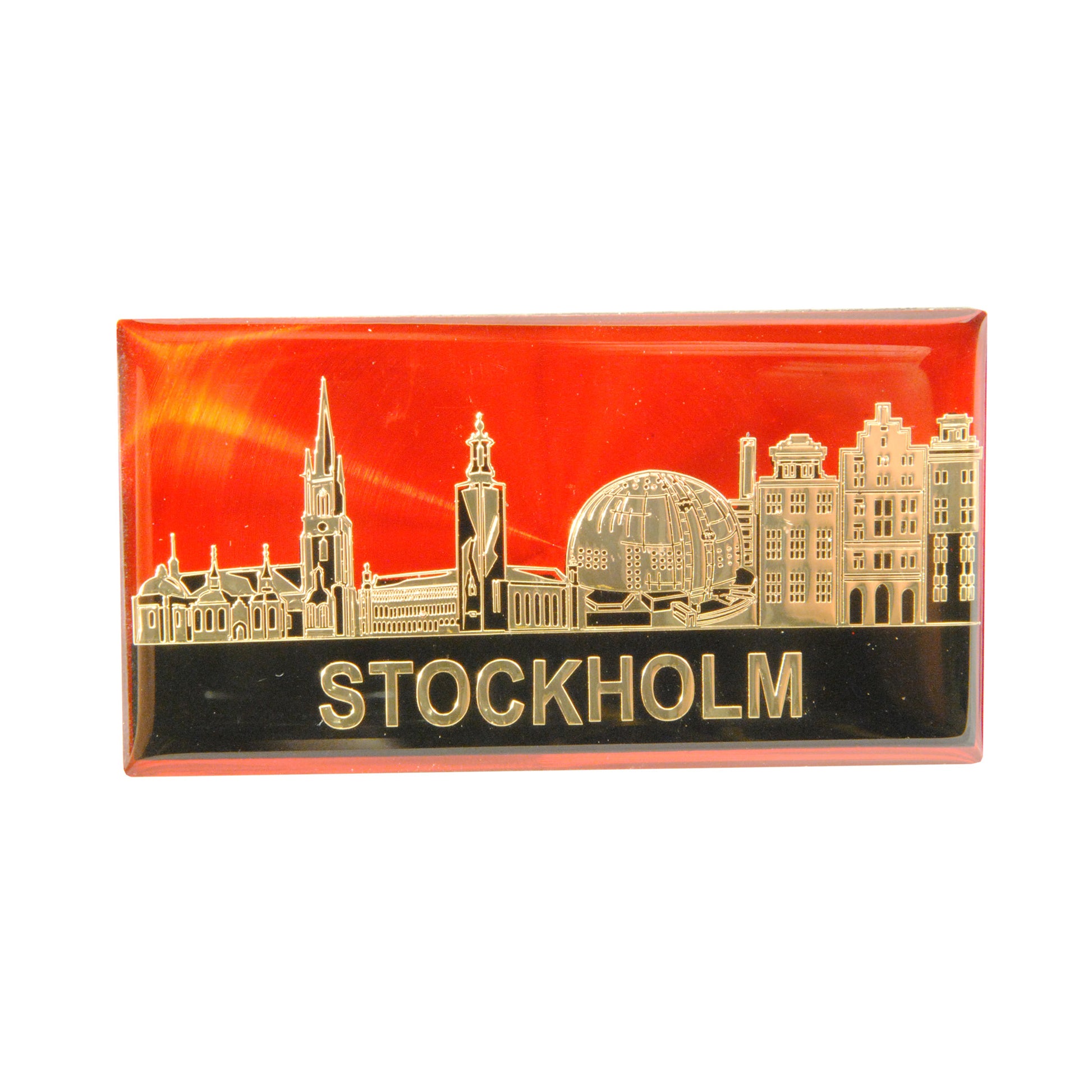 Epoxymagnet med Stockholms skyline i guld på röd bakgrund. Stilren och elegant souvenir med tydlig kontrast.