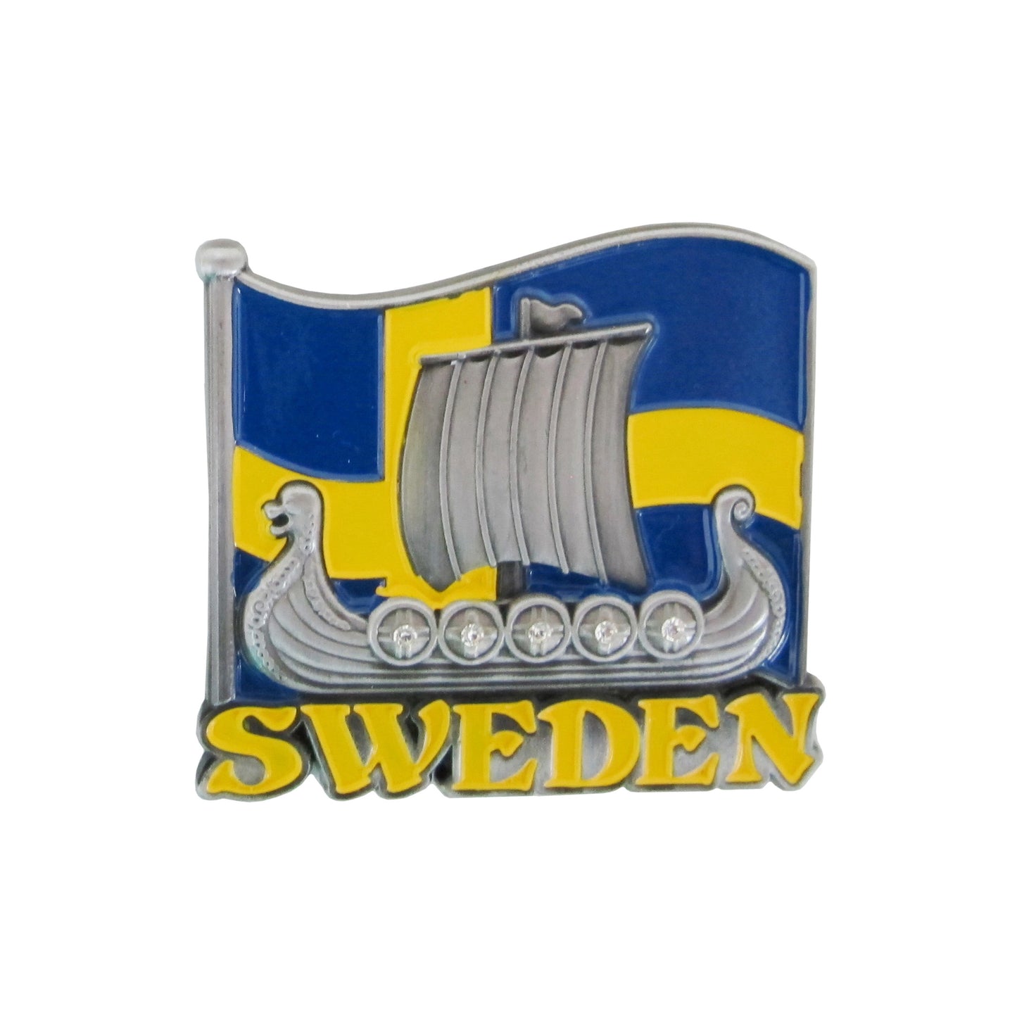 Bild på metallmagnet med vikingaskepp i 2D och svenska flaggan i bakgrunden. Vikingaskeppet är i tennfärg med dekorativa stenar på sköldarna.