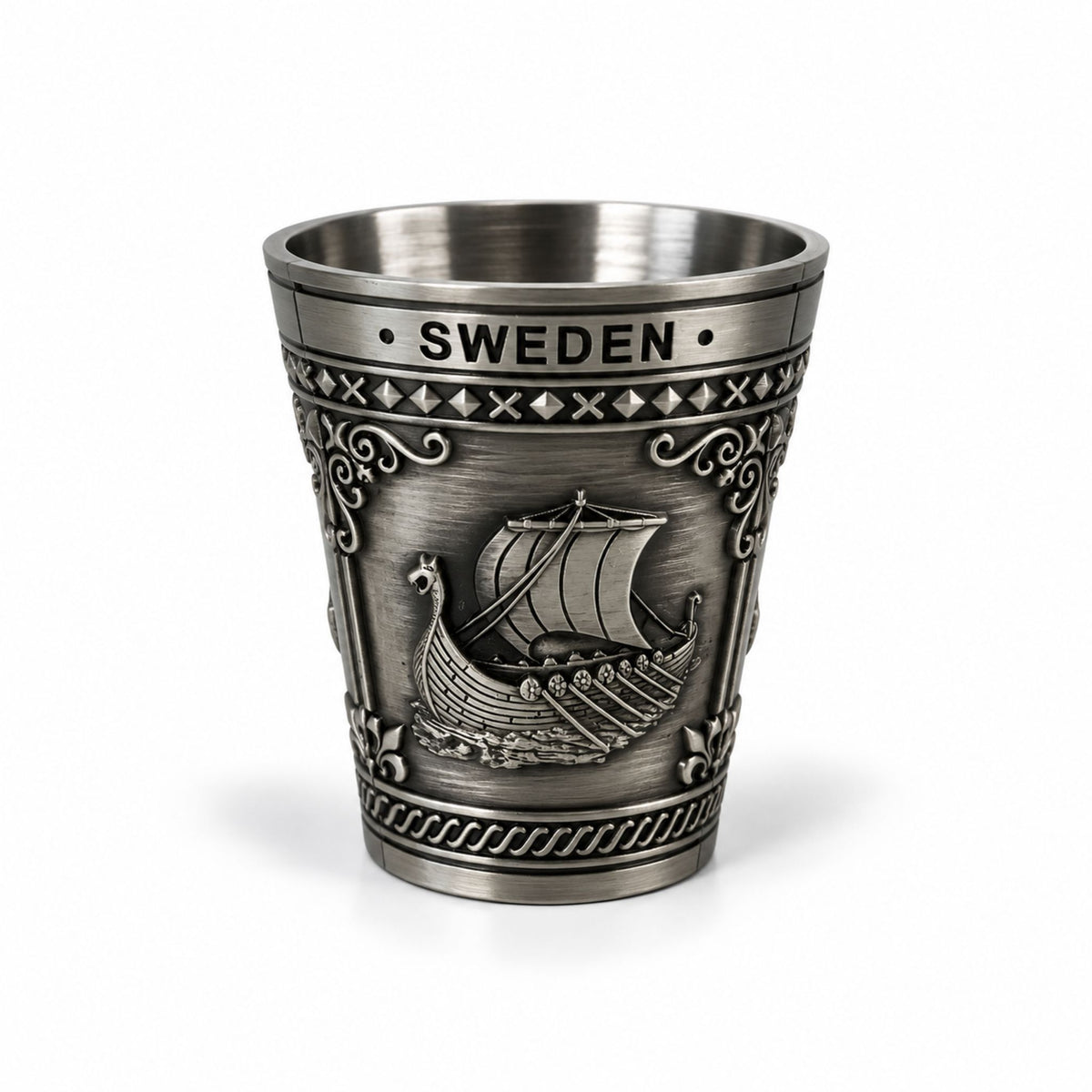 Metall-shotglas med 3 olika Sverigemotiv:  älg, karta och vikingaskepp. Här visas ena sidan av glaset som är dekorerat med ett vikingaskepp och texten Sweden. 
