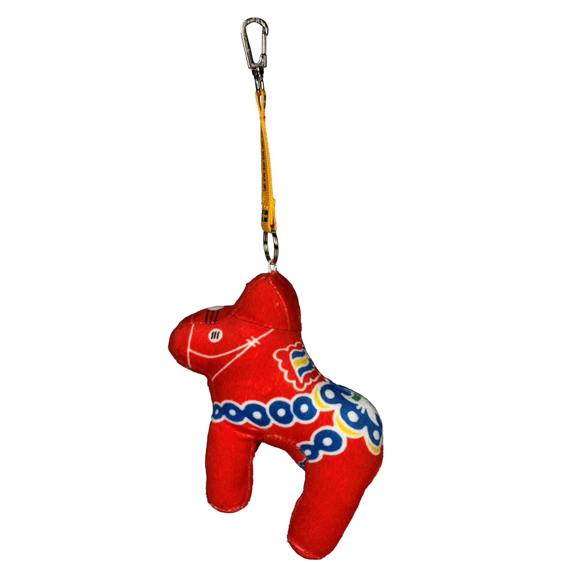Mjuk dalahäst med gult keyband med två svenska flaggor och texten "SWEDEN". Sedd från sidan.