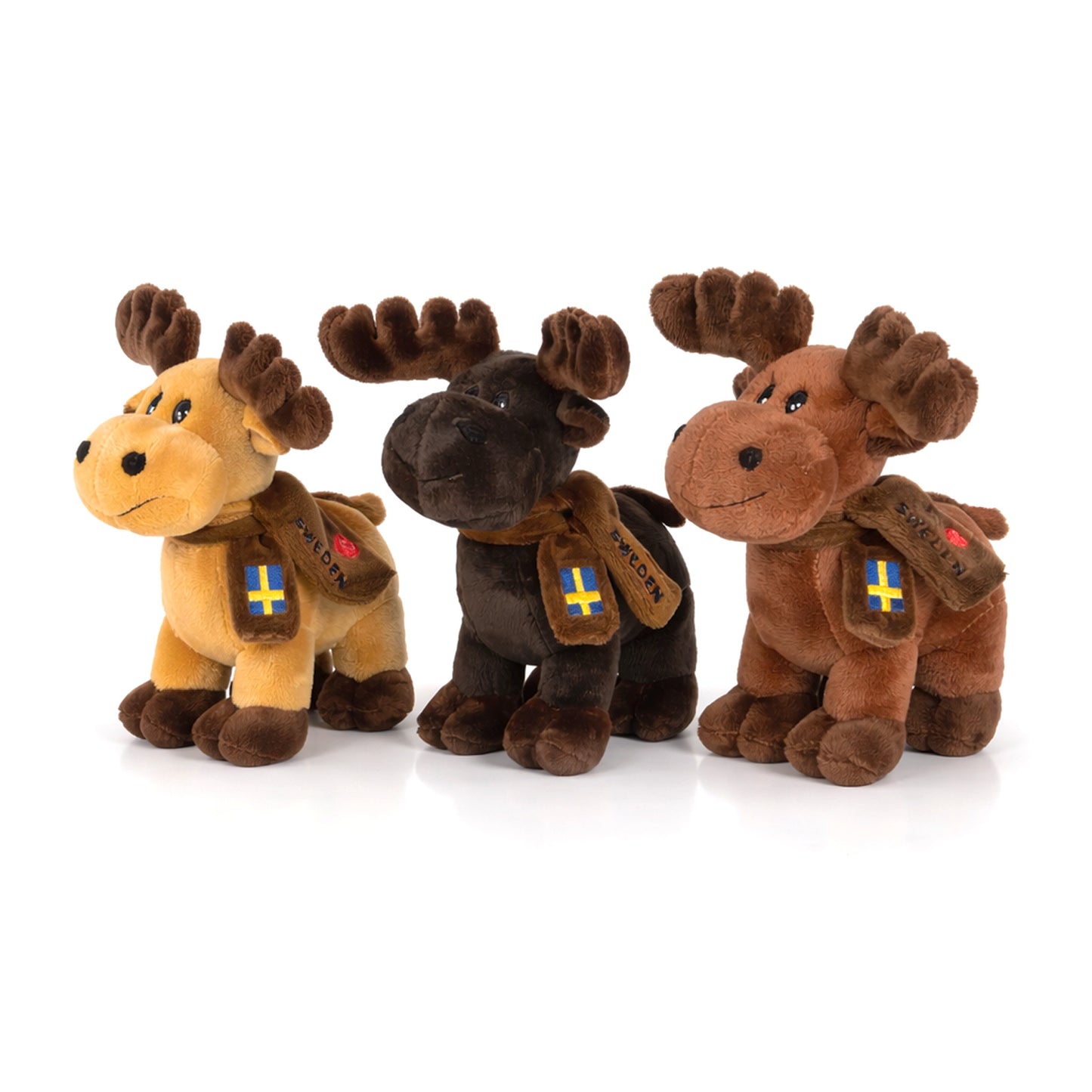 Tre stående gosedjursälgar på 16 cm med "I Love Sweden"-halsdukar – en mörkbrun, en brun och en beige älg, alla med glatt uttryck och charmig design. Perfekta som souvenirer eller samlarobjekt.