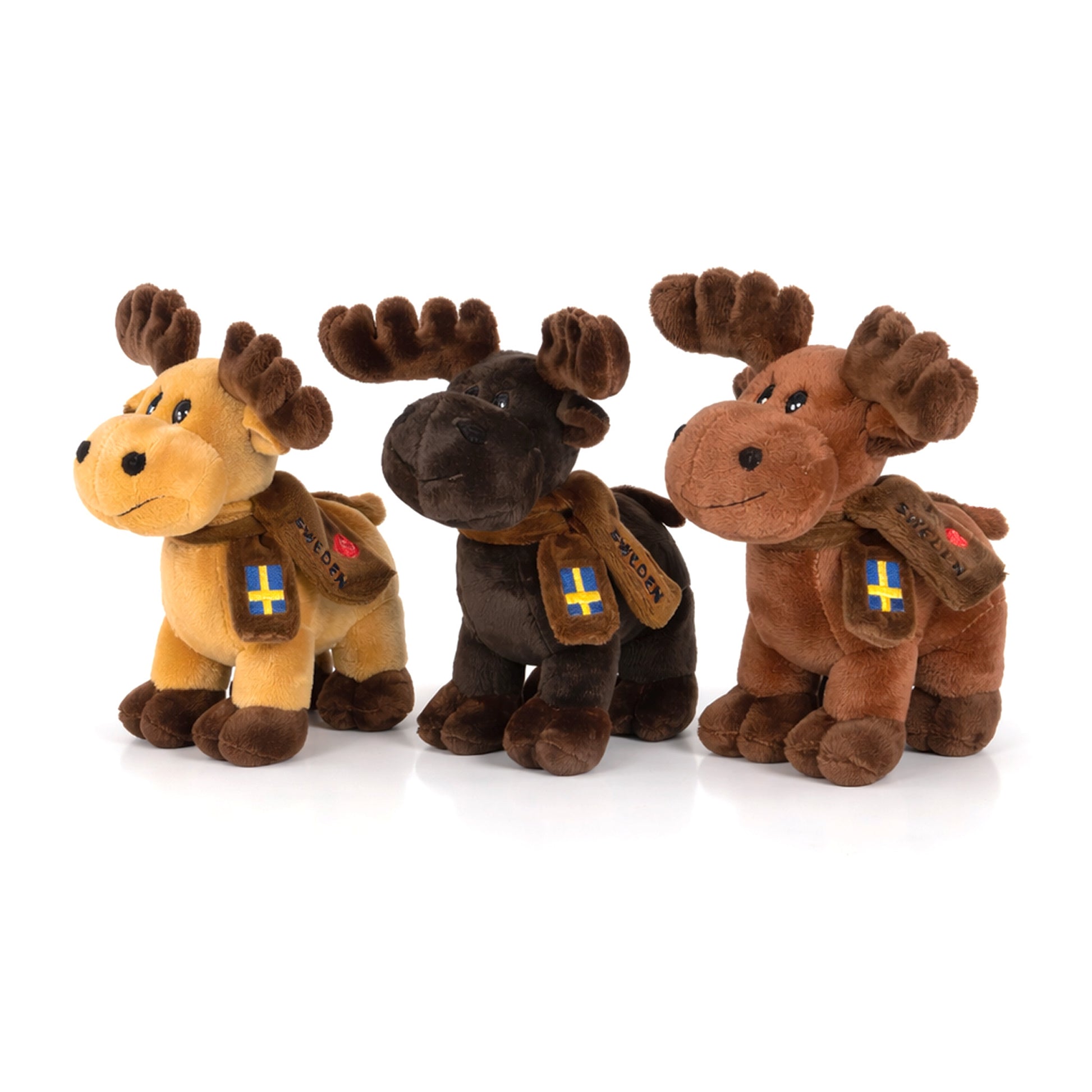 Tre stående gosedjursälgar på 16 cm med "I Love Sweden"-halsdukar – en mörkbrun, en brun och en beige älg, alla med glatt uttryck och charmig design. Perfekta som souvenirer eller samlarobjekt.