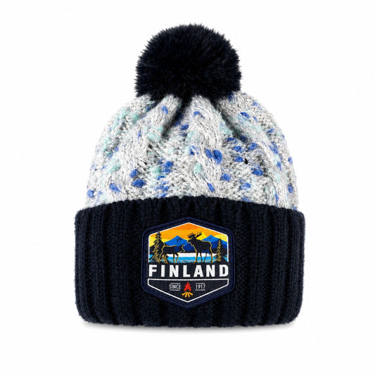 Stickad mössa med blå tofs och märke med texten Finland på mudden - sedd framifrån. 