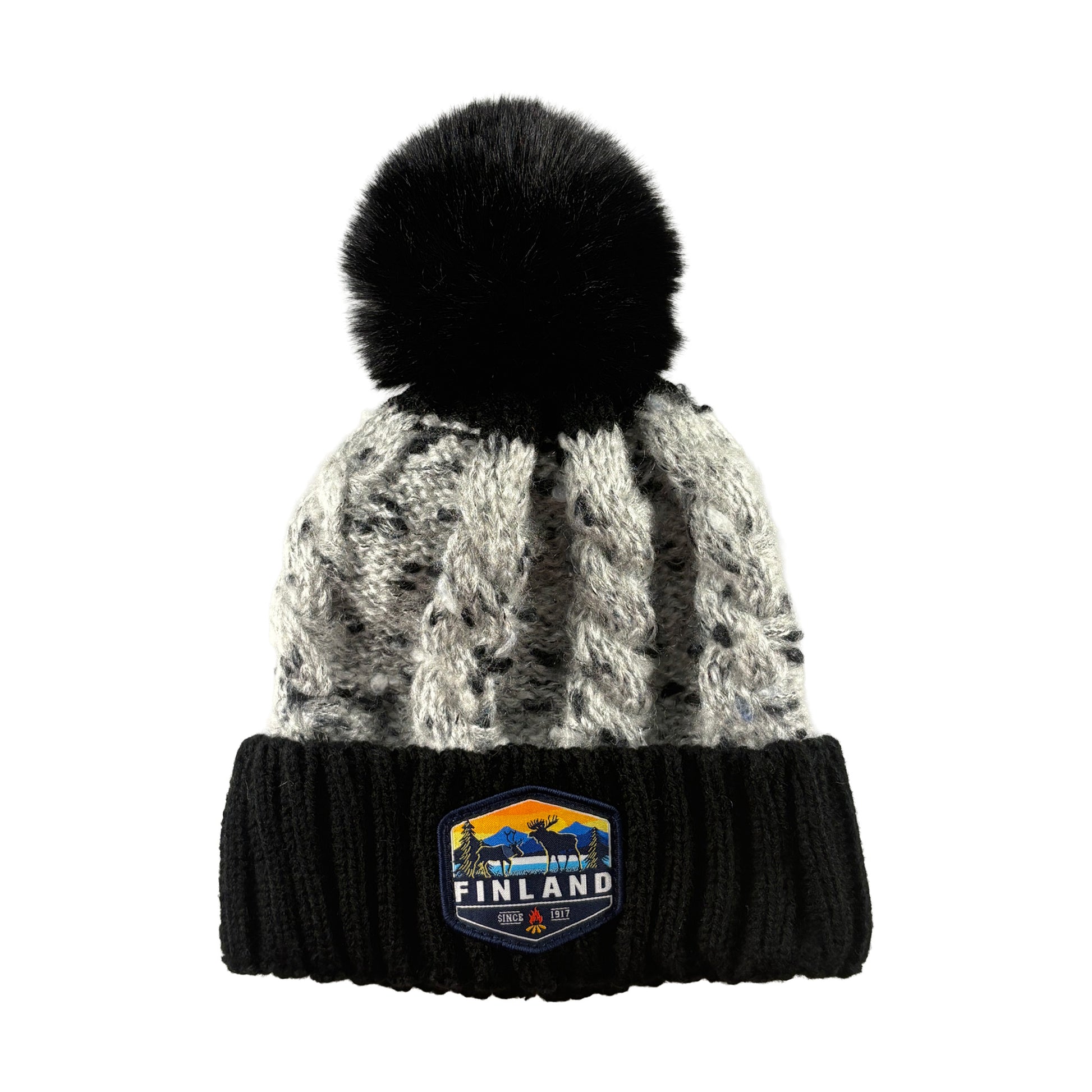 Stickad svart mössa med svart tofs och märke med texten Finland på mudden - sedd framifrån. 