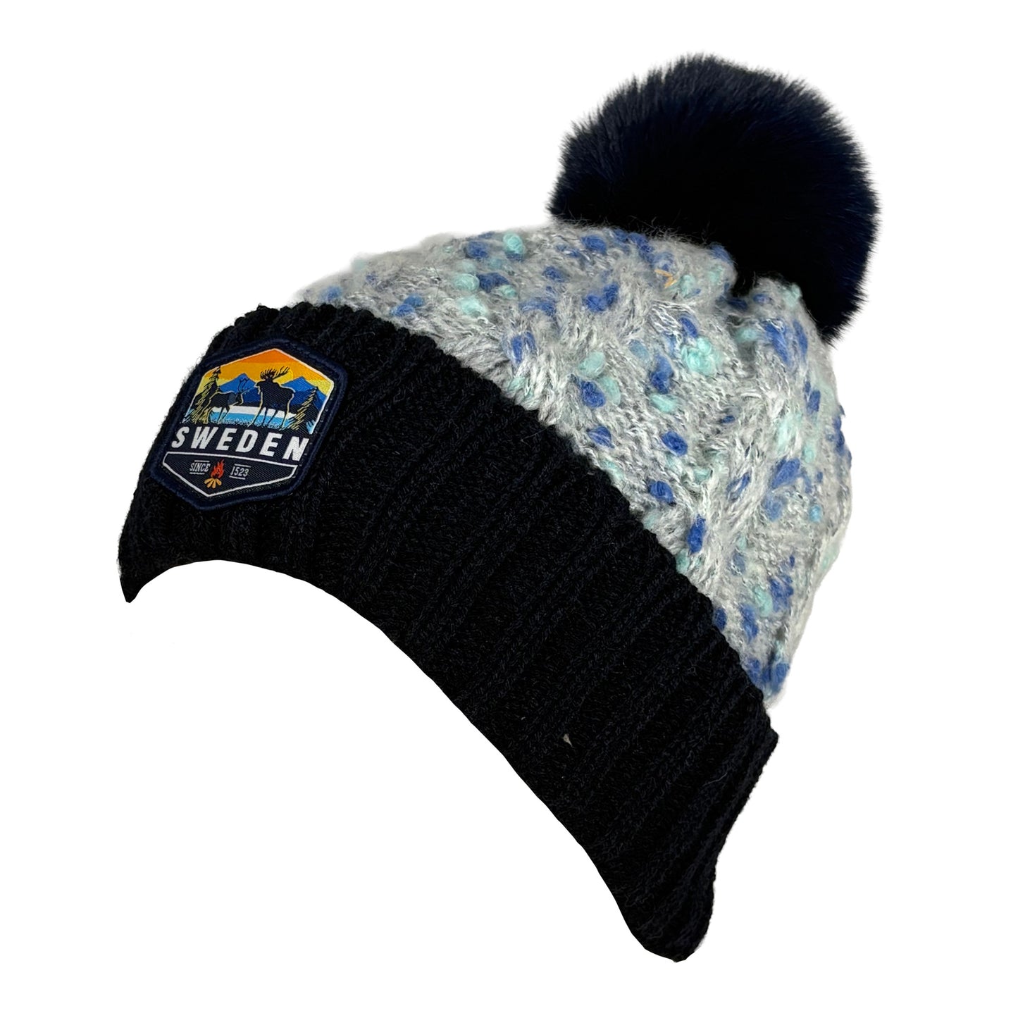 Stickad mössa i blått och grått med blå tofs, sedd från sidan. 