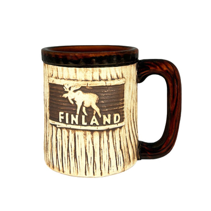 Mugg med älgmotiv och texten 'FINLAND'. Mönstret ger en träliknande effekt och handtaget samt kanten upptill har en mörkbrun färg.  Ger en naturtrogen känsla.