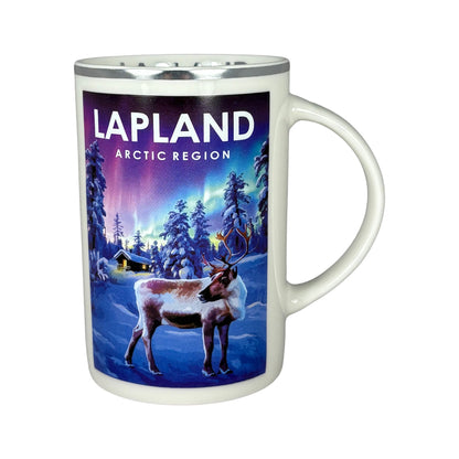 Vit mugg sedd framifrån med handtaget åt höger, med motiv av ett vackert vinterlandskap, en ren och norrsken i bakgrunden.