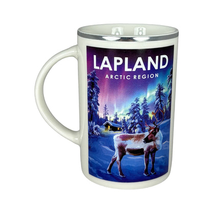 Vit mugg sedd framifrån med handtaget åt vänster, visar att motivet med vinterlandskap, ren och norrsken finns på båda sidor.