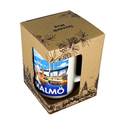 Souvenirmugg Malmö Silverkant i presentförpackning, pappkartong med skogsmotiv och texten “Souvenir Mug” på toppen.