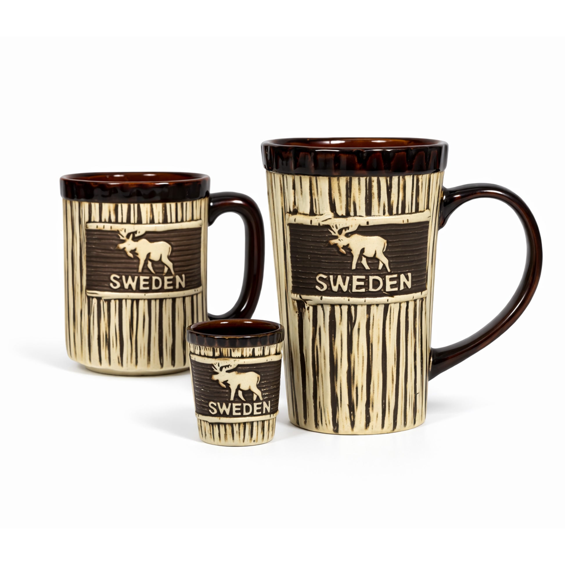 Våran serie med mugg, shotglas och lattemugg i ett träliknande utseende men älg och texten "SWEDEN". Muggen har en brun kant upptill och även bruna handtag på mugg och lattemugg. 