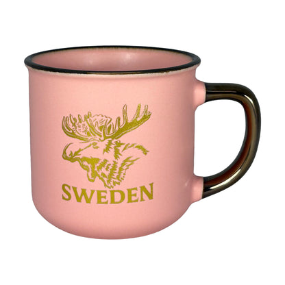 Aprikosfärgad mugg med guldfärgat älgmotiv och texten "Sweden" – elegant souvenir.