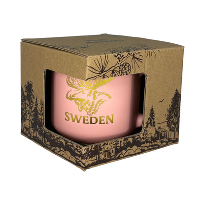 Aprikosfärgad mugg i brun kartong med mörkbrunt skogsmotiv, sedd framifrån.