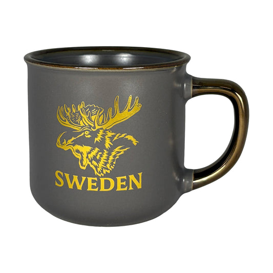 Grå mugg med guldfärgat älgmotiv och texten "Sweden" – sedd framifrån.