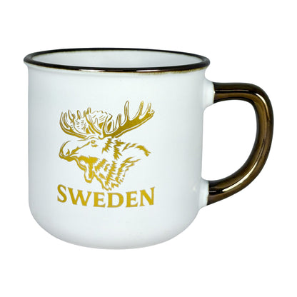 Gräddvit mugg med guldfärgat älgmotiv och texten "Sweden" – framsidan.