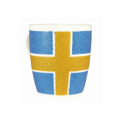 Vit porslinsmugg med svensk flagga och glittereffekt.