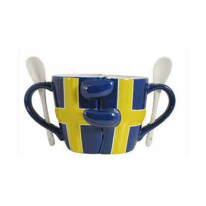 En mugg som kan delas i två. Varje mugg pryds av svenska flaggan. I handtaget på varje mugg sitter en vit sked. 