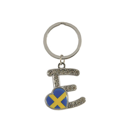 Metallnyckelring med bokstaven E. Bokstaven är dekorerad med glitterstenar. På bokstaven finns även ett hjärta med en svensk flagga.