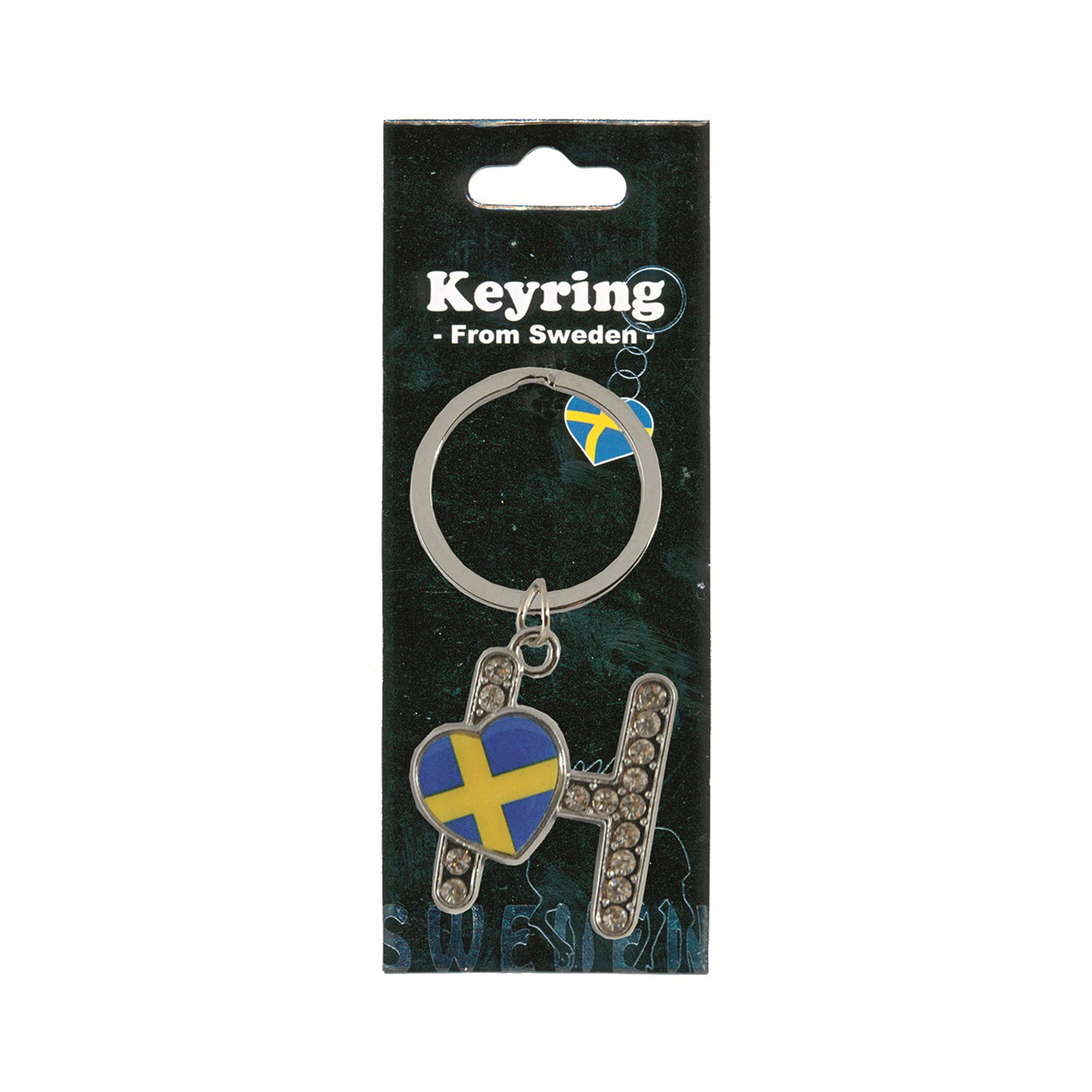 Metallnyckelring med bokstaven H. Bokstaven är dekorerad med glitterstenar. På bokstaven finns även ett hjärta med en svensk flagga. Visas här i sin förpackning. Svart förpackning med  texten "Keyring från Sweden" i vitt.