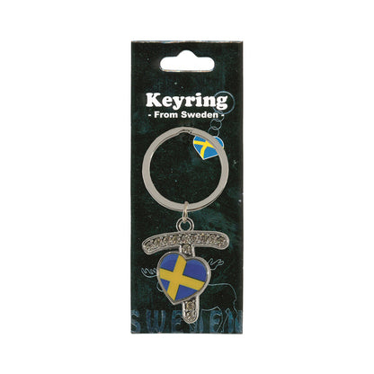 Metallnyckelring med bokstaven T. Bokstaven är dekorerad med glitterstenar. På bokstaven finns även ett hjärta med en svensk flagga. Visas här i sin förpackning. Svart förpackning med  texten "Keyring från Sweden" i vitt.