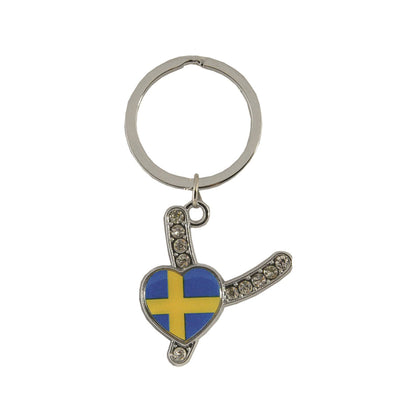 Metallnyckelring med bokstaven Y. Bokstaven är dekorerad med glitterstenar. På bokstaven finns även ett hjärta med en svensk flagga.