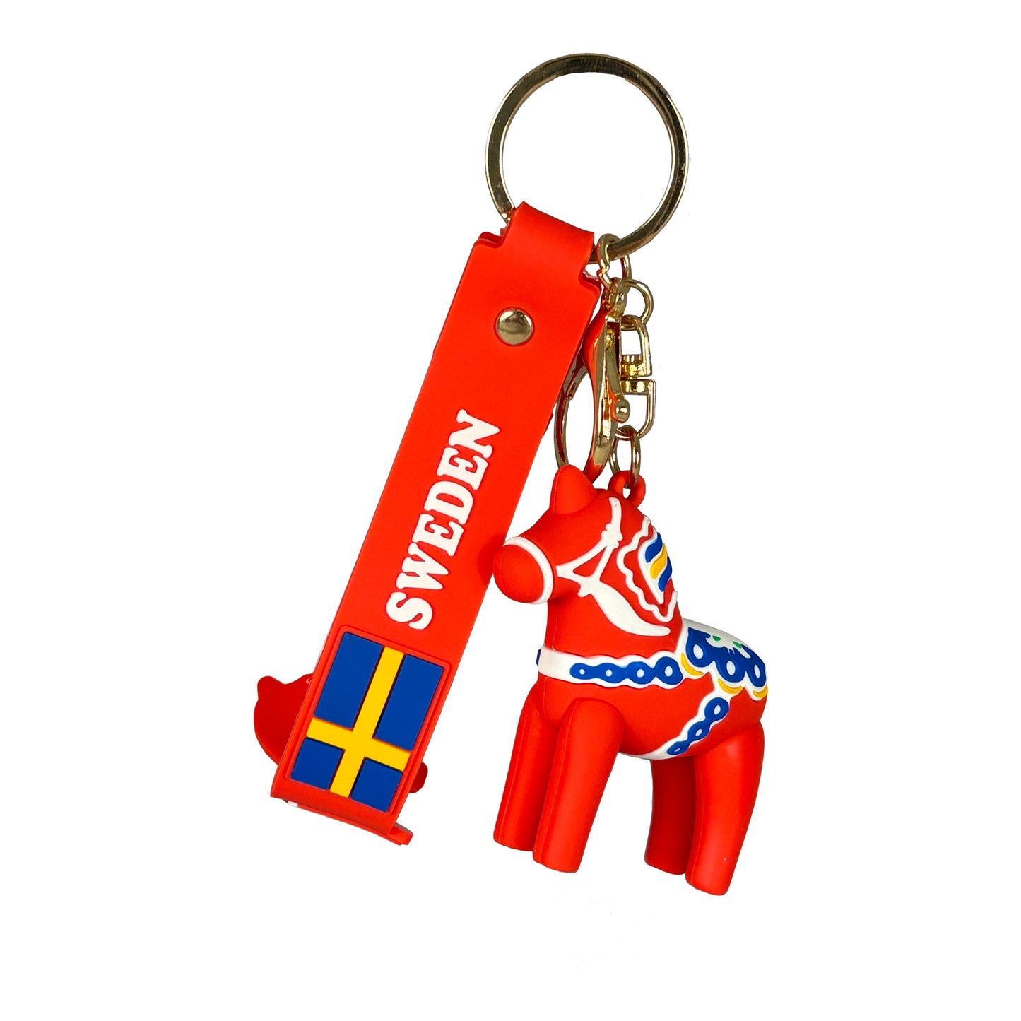 Nyckelring hängande, bestående av en röd PVC rem med svensk flagga, texten "Sweden", en dalahästfigur och en guldfärgad nyckelring.